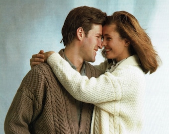 May include: A couple wearing matching cable knit cardigans. The man's cardigan is brown and the woman's cardigan is white.