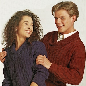 May include: A couple wearing matching cable knit sweaters with a cowl neck. The woman is wearing a navy blue sweater and the man is wearing a burgundy sweater.