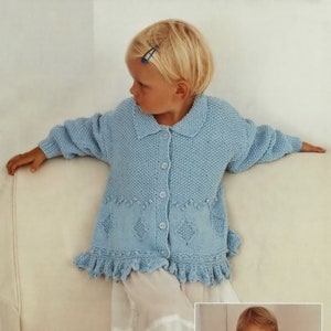 May include: Two children wearing knitted cardigans with lace edging. The cardigan on the left is light blue and the cardigan on the right is white. "Textured cardigan with pretty lace edging" is written at the bottom of the image.