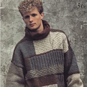 Puede incluir: Un suéter patchwork en tonos marrones, grises y beige. El suéter tiene un cuello alto y está hecho de varios patrones de punto texturizados. La palabra "Samband" está impresa en la parte inferior de la imagen. El número "56" está en la esquina superior derecha.