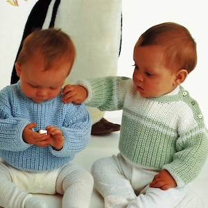 Peut inclure: Deux bébés portant des pulls en tricot. Un bébé porte un pull bleu clair et l'autre un pull rayé vert et blanc.