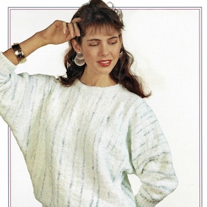 May include: A white and light blue striped sweater with a round neckline. The sweater has a relaxed fit and is made of a soft, textured fabric.