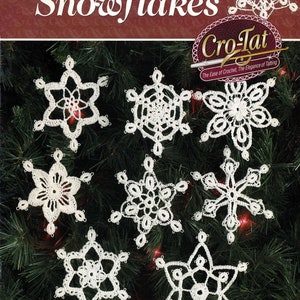 May include: A close-up of 18 white crocheted snowflakes on a green pine tree branch. The snowflakes are made with size 10 crochet thread and an easy new technique. The text "Cro-Tat The Ease of Crochet, The Elegance of Tatting" is visible in the image.