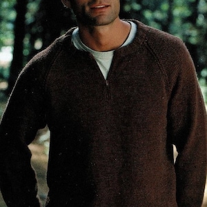 May include: A brown knitted sweater with a zippered neckline. The sweater has a ribbed hem and cuffs.