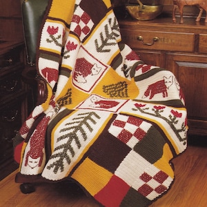 Puede incluir: Una manta de patchwork de ganchillo con un tema de bosque. La manta presenta una variedad de diseños, incluyendo árboles, zorros y flores. La manta está hecha en una variedad de colores, incluyendo rojo, verde, marrón y amarillo.