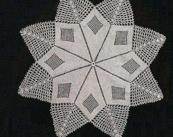 May include: A white crocheted doily in the shape of a star with a detailed design.