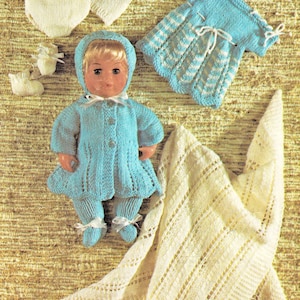 Puede incluir: Un conjunto de ropa de punto para muñeca en azul y blanco. El conjunto incluye un vestido, una chaqueta, pantalones, un gorro, botines y un pañal. La muñeca no está incluida.