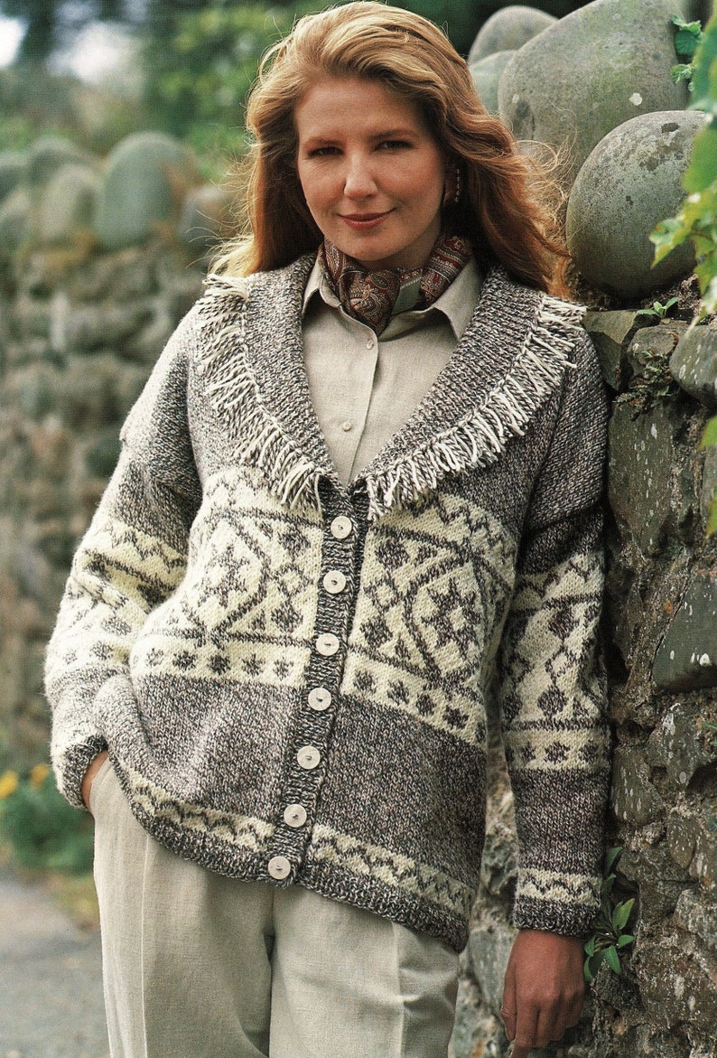 May include: A gray and white knitted cardigan with a fringe trim collar and button closure. The cardigan features a geometric pattern.