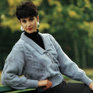 May include: A light blue knitted cardigan with a cable knit pattern and a button closure. The cardigan has a v-neck and long sleeves.