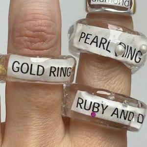 clear resin ring with text – gold, pearl, ruby and diamond, conceptual jewelry