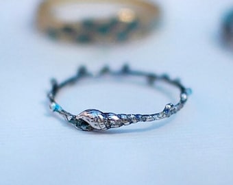 Könnte beinhalten: Ein silberner Ring mit einem Zweigdesign und einem Blattdetail. Der Ring ist aus Metall und hat einen rustikalen Look.