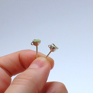Peut inclure: Une paire de boucles d'oreilles en argent avec de petites tasses vertes attach&eacute;es aux extr&eacute;mit&eacute;s.