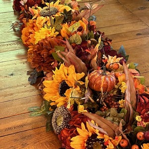 Puede incluir: Un camino de mesa de oto&ntilde;o con girasoles, calabazas, bayas y hojas en tonos naranja, amarillo, marr&oacute;n y rojo.