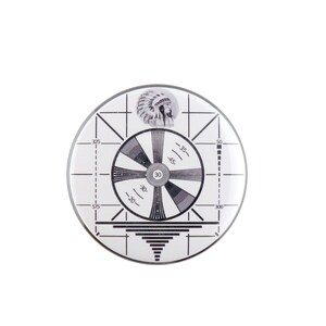May include: A black and white circular test pattern with a Native American head in the center. The pattern includes a circle with radiating lines, a grid, and numbers indicating degrees. The text "30" is in the center of the circle.