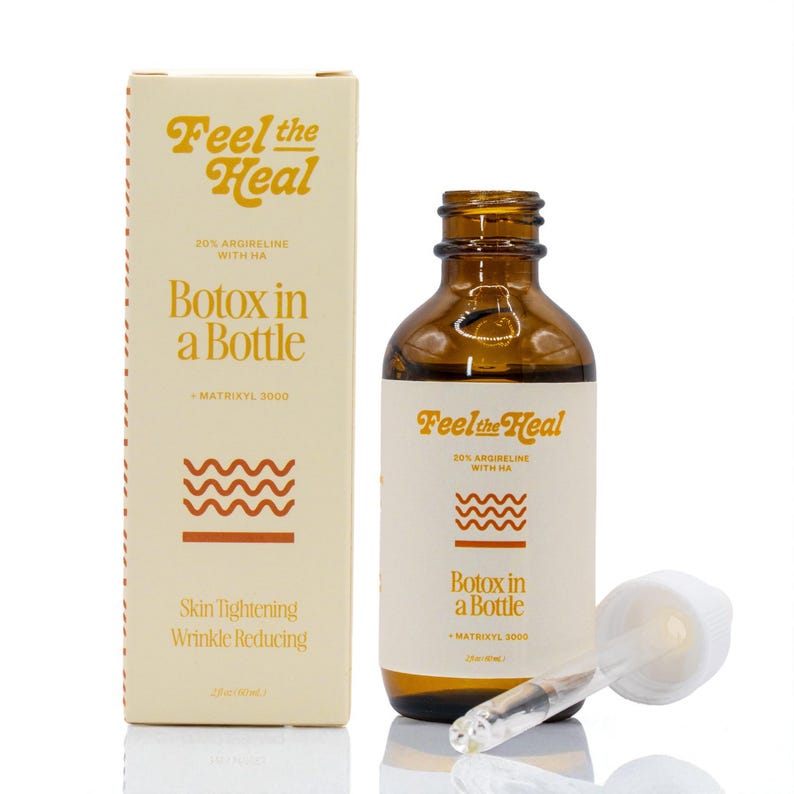 May include: A brown glass bottle and a matching box with the text "Feel the Heal" in a retro font. The bottle and box have labels that read "Botox in a Bottle" and "Skin Tightening Wrinkle Reducing". A dropper is next to the bottle.