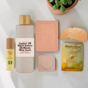 May include: A set of three ceramic mugs with a speckled, cream-colored glaze. Each mug features a different hand-painted design: a blue and green leaf, a yellow flower, and a red berry. The mugs have a simple, rounded shape.