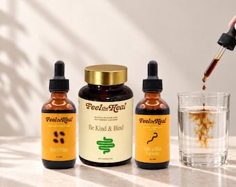 Può includere: Due flaconi contagocce in vetro ambrato etichettati Feel the Heal Bye O Film e Take a Hike Parasite, e un barattolo in vetro ambrato etichettato Feel the Heal Be Kind & Bind con coperchio dorato. Un contagocce versa del liquido scuro in un bicchiere d'acqua.