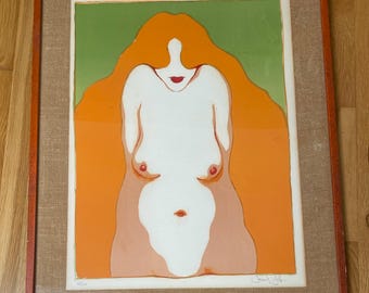 May include: A framed print of a woman with long, flowing orange hair. The woman is nude and her body is depicted in a stylized, abstract manner. The background is a muted green color.