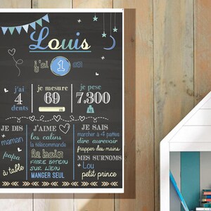 May include: A chalkboard style poster with a blue and white design. The poster says "Louis" and includes details about the child's age, height, weight, and likes. The poster says "j'ai 4 dents", "je mesure 69", "je pese 7.300", "je dis maman", "j'aime les calins", "la t&eacute;l&eacute;commande", "papa le bain", "faire bateau sur l'eau", "manger seul", "je sais marcher &agrave; 4 pattes", "dire au revoir", "frapper des mains", "mes surnoms * Lou", "petit prince".