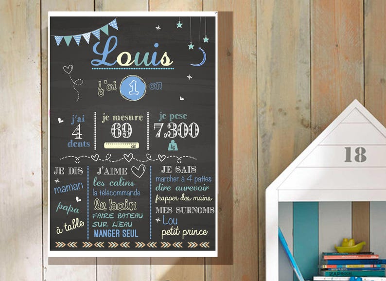 May include: A chalkboard style poster with a blue and white design. The poster says "Louis" and includes details about the child's age, height, weight, and likes. The poster says "j'ai 4 dents", "je mesure 69", "je pese 7.300", "je dis maman", "j'aime les calins", "la t&eacute;l&eacute;commande", "papa le bain", "faire bateau sur l'eau", "manger seul", "je sais marcher &agrave; 4 pattes", "dire au revoir", "frapper des mains", "mes surnoms * Lou", "petit prince".