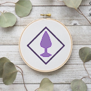 May include: A purple Celtic knot design in a diamond shape on a white background. The design is in a hoop.