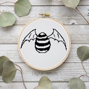 Puede incluir: Patrón de punto de cruz en blanco y negro de una luna celta con alas en un aro de bordado redondo. El texto "Celtic Moon Black" está por encima del aro y "Digital Pattern" está por debajo del aro.