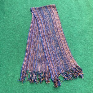 May include: A blue and orange striped scarf with fringe on the ends.