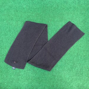 May include: A dark grey ribbed knit scarf with a small white and red logo tag.