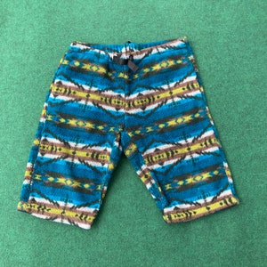 Könnte beinhalten: Blaue, braune, weiße und gelbe gemusterte Fleece-Shorts mit Kordelzug.