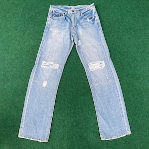 Könnte beinhalten: Hellblaue Jeans aus Denim mit abgenutzten Details und mehreren Rissen und Löchern an den Beinen.