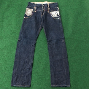 May include: Dark blue denim jeans with colourful stitching and a white graphic on the right leg that says "MASTER" with a star design. The left pocket has a white patch with the word "FAT" on it.