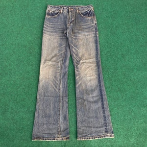 May include: A pair of blue denim jeans with a bootcut style. The jeans have a faded look and are made of a soft, comfortable fabric.
