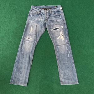 May include: A pair of blue denim jeans with distressed details and multiple rips and tears throughout the fabric.