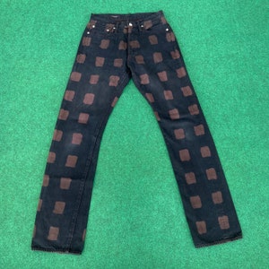 May include: Black denim jeans with a brown checkered pattern.