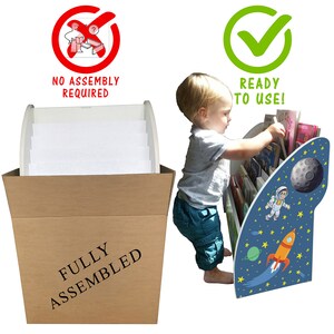 May include: A white and blue children's bookshelf with a rocket and astronaut design. The bookshelf is fully assembled and ready to use. A child is reaching for a book on the shelf.