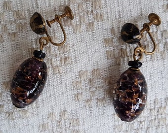 The dangling vintage brown black earrings of glass beads and metal parts.