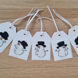 5 étiquettes cadeaux faites à la main de bonhomme de neige de Noël.