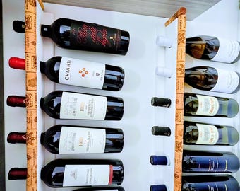 May include: A wine rack made of wood, holding several bottles of wine. The bottles are arranged horizontally and feature a variety of labels and colours. The rack is attached to a white wall, providing a stylish storage solution for wine bottles.