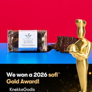 May include: A clear plastic package of dark chocolate bark with a white label reading Norwegian BAKED KNEKKEGODIS, next to a gold-colored chef trophy. Text on the black lower section reads We won a 2026 sofi Gold Award! KnekkeGodis Norwegian Baked.