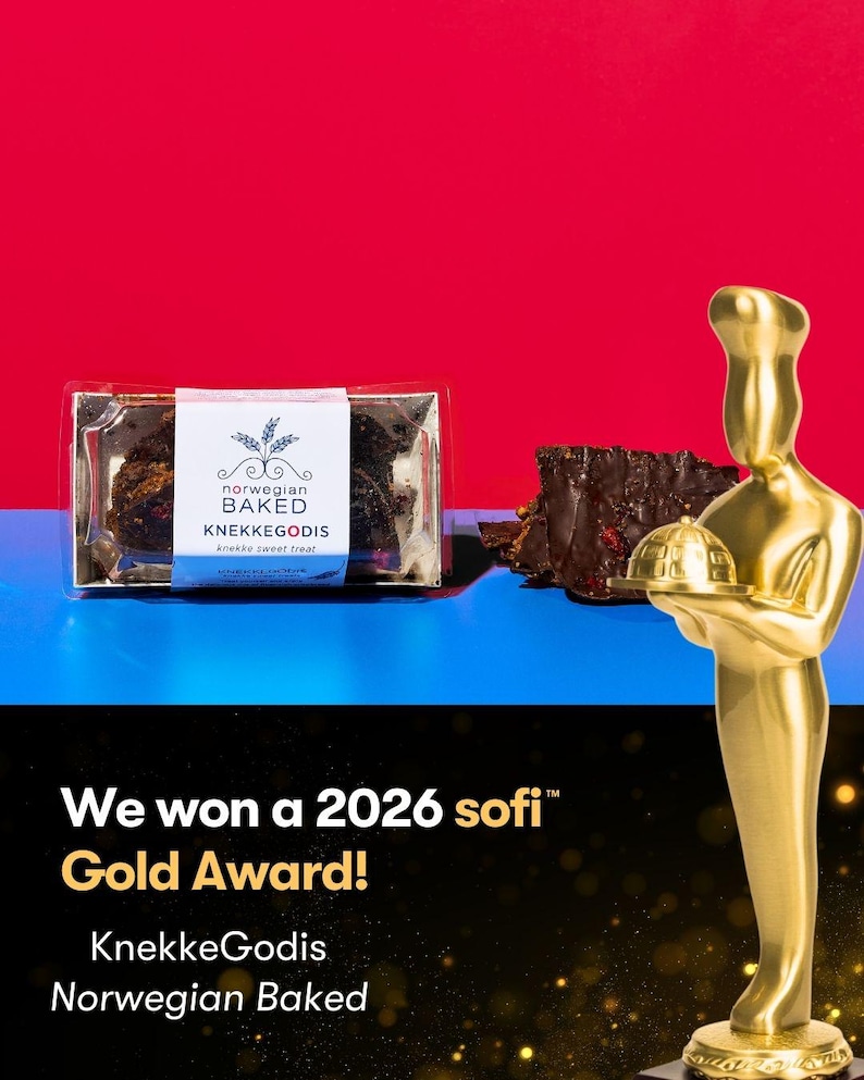 May include: A clear plastic package of dark chocolate bark with a white label reading Norwegian BAKED KNEKKEGODIS, next to a gold-colored chef trophy. Text on the black lower section reads We won a 2026 sofi Gold Award! KnekkeGodis Norwegian Baked.
