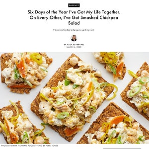 May include: A top-down view of five rectangular seeded crackers topped with a creamy smashed chickpea salad, garnished with sliced green onions and yellow pepper strips. The text reads: Basically, Six Days of the Year I've Got My Life Together. On Every Other, I've Got Smashed Chickpea Salad. It loves me at my best and props me up at my worst.