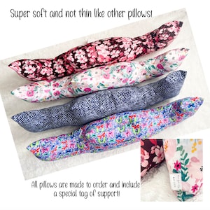 May include: Four long, bolster-style pillows with floral and patterned designs. The pillows are in shades of pink, white, blue, and purple. The text reads "Super soft and not thin like other pillows!" and "All pillows are made to order and include a special tag of support!"