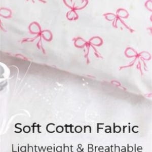 May include: White fabric with a repeating pattern of pink bows. The text "Soft Cotton Fabric" and "Lightweight & Breathable" are displayed below the fabric.