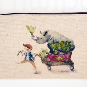 May include: A white canvas zippered pouch with a watercolor illustration of a rhinoceros pulling a red wagon full of vegetables. A boy in blue pants and a blue vest is running behind the wagon.