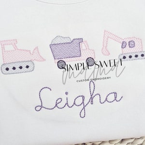 May include: A white onesie with embroidered pink and purple construction vehicles and the name "Leigha" in purple thread.