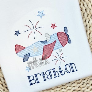 May include: Embroidered design of a red, white, and blue airplane flying over fireworks with the name Brighton stitched below.