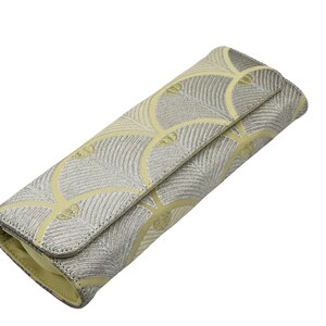 May include: A silver and yellow clutch bag with a geometric pattern. The bag is closed and has a flap.