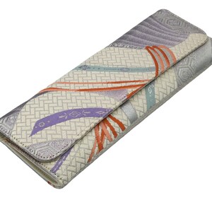 Puede incluir: Un embrague blanco y plateado con un estampado floral colorido. El embrague tiene un cierre de solapa y una cremallera plateada.