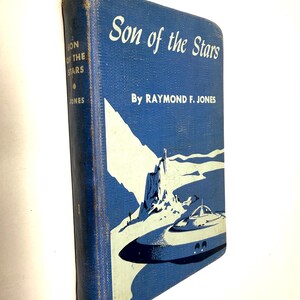May include: A vintage hardcover book titled "Son of the Stars" by Raymond F. Jones. The book has a blue cover with white text and a retro illustration of a spaceship and landscape. The spine shows the title and author's name.