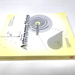 May include: A yellow and white book titled "Astronomy Notes" by Nick Strobel. The 2013 edition includes a CD-ROM. The cover features a diagram of the Milky Way galaxy and a spiral galaxy.